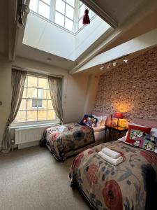 une chambre avec deux lits et une lucarne dans l'établissement Luxury Cottage in the Heart of Bath, à Bath
