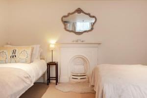 une chambre avec deux lits et un miroir au mur dans l'établissement Luxury Cottage in the Heart of Bath, à Bath 37 autres photos