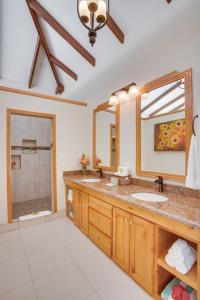 a bathroom with two sinks and a large mirror at Coco Plum All Inclusive Resort in Dangriga
