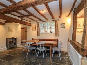 ein Esszimmer mit einem Holztisch und Stühlen in der Unterkunft April Cottage in Chipping Campden