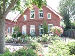 a red brick house with flowers in front of it at Ferienwohnung Sabath, 15105 in Leer