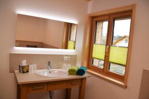a bathroom with a sink and a mirror at Naturhaus Altmuehltal in Titting +10 photos
