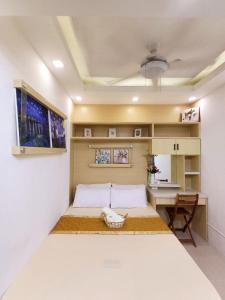 une petite chambre avec un lit et un bureau dans l'établissement My Staycation moa area S Residences tower1, à Manille