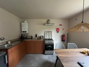 a kitchen with a stove and a table with chairs at Naturehome Avô in Avô