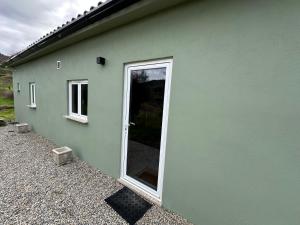 a green building with a door and a window at Naturehome Avô in Avô +4 photos