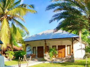 ギリ・アイルにあるGusung Indah Bungalow Gili Airの前にヤシの木がある家