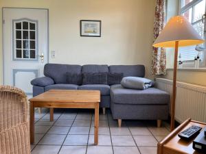 a living room with a blue couch and a table at Parkstrasse -Whg1 in Wyk auf Föhr
