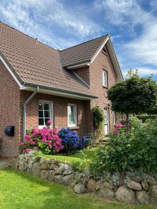 a brick house with flowers in the yard at Nordwind in Oevenum