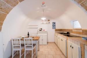 a kitchen with a table and chairs in a room at Dimora Cantalupi by Vivimy in Gallipoli +8 photos