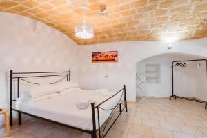 a bedroom with a bed and a brick wall at Dimora Cantalupi by Vivimy in Gallipoli