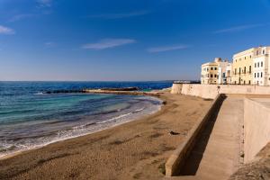 a sandy beach with buildings and the ocean at Dimora Cantalupi by Vivimy in Gallipoli