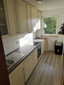 a kitchen with white cabinets and a sink and a window at Ferienwohnung Dreher in Aulendorf