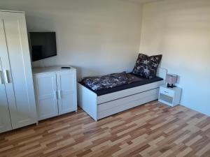 a small room with a bed and a tv at Ferienwohnung Dreher in Aulendorf
