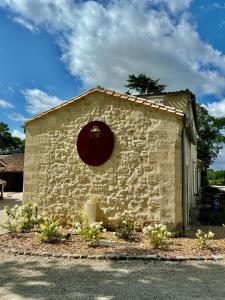 een klein bakstenen gebouw met een rond raam bij L'Eperonnette, cozy house with swimming pool, surrounded by vineyard, near St Emilion in Vérac