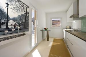 a kitchen with white walls and a large window at Marieta bajo in Colònia De Sant Jordi +4 photos
