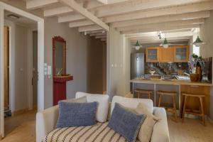 a living room with a couch and a kitchen at Paleros Stone in Paleros