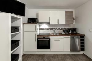 a kitchen with white cabinets and a sink at Ferienwohnung Ohechaussee in Norderstedt