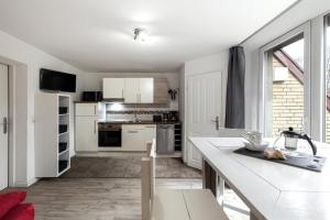a kitchen with white cabinets and a large window at Ferienwohnung Ohechaussee in Norderstedt