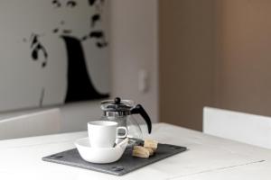 a coffee pot and a cup on a table at Ferienwohnung Ohechaussee in Norderstedt