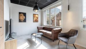 a living room with a couch and a television at Le Dauphine 3 Allevard in Allevard