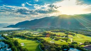 an aerial view of a golf course with mountains in the background at Nha Trang Marriott Resort & Spa, Hon Tre Island in Nha Trang