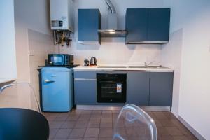 a kitchen with blue cabinets and a sink and a dishwasher at Bigattera Apartments in Varese