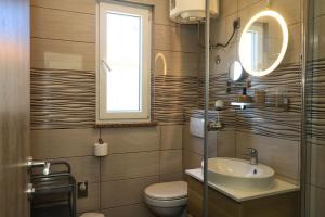 a bathroom with a sink and a toilet and a window at Apartment Mili in Betina +53 photos