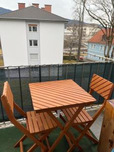 莱奥本Gemütliche Stadtwohnung Leoben, Gratis Parkplätze的阳台上配有一张木桌和两把椅子