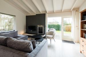 a living room with a couch and a tv at Valkenhoek (4p) in Ballum