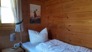 a bedroom with a bed in a log cabin at Blockhaus Stamsried in Stamsried +16 photos