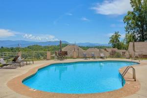 a swimming pool at a resort with mountains in the background at A Dolly Good Time in Sevierville