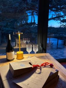 a bottle of wine and wine glasses on a table at Mas Hinaiti - Suite romantique avec Spa et écran géant de cinéma in Montpellier