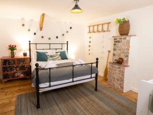 a bedroom with a bed and a fireplace at Dyffryn Cottage in Cardigan