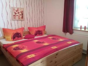 a bedroom with a large wooden bed with pink sheets at Landhaus im Grünen - Carpe Diem in Grammendorf