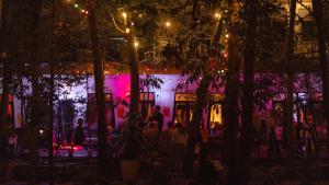 a group of people standing in front of a building at night at MESTO Koh Phangan - Creative Stay & Community Hub in Thong Sala
