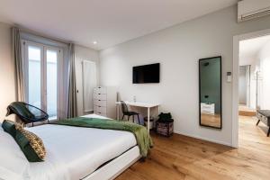 科莫Hidden Lodge - by MyHomeInComo的卧室里有一张床、一张书桌和一面镜子