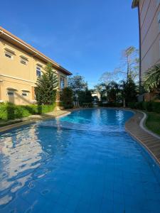 a swimming pool with blue water in front of a building at Vista Manors Verdant Palawan in Puerto Princesa