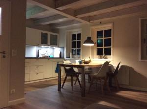 a kitchen with a table and chairs in a room at Auszeit in Oldsum