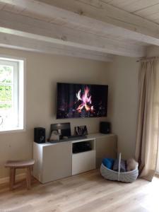 a living room with a flat screen tv on the wall at Auszeit in Oldsum