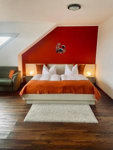a bedroom with a large bed with a red headboard at Hotel Reindahls in Wilkendorf