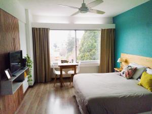 a bedroom with a bed and a table and a window at Nothofagus Apartments in San Carlos de Bariloche