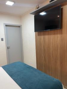 a bedroom with a bed and a flat screen tv on a wall at Pousada Del Mares in Fernando de Noronha +140 photos