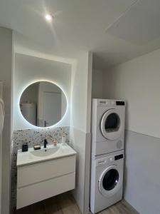 a bathroom with a sink and a washing machine at Maison 4 chambres & jardin à Chéray in Saint-Georges-dʼOléron