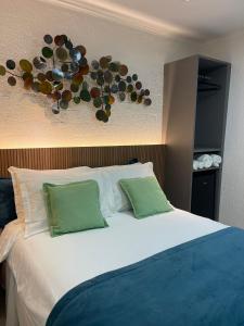 a bed with two pillows and a decoration on the wall at Pousada Del Mares in Fernando de Noronha
