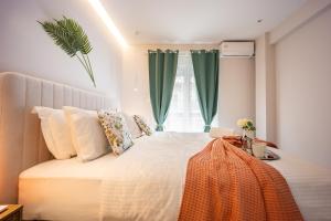 a bedroom with a large bed with green curtains at Elegant Aphrodite, 2 Bedroom Apartment, by Acropolin in Athens