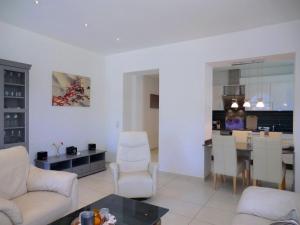 a living room with white furniture and a kitchen at Seestern - Whg 2 in Wyk auf Föhr
