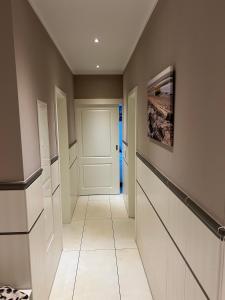 a hallway with a white door and a painting on the wall at Seestern - Whg 2 in Wyk auf Föhr +10 photos