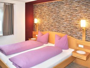 a bedroom with two beds with purple pillows at Apartment Miramonte-3 by Interhome in Kappl