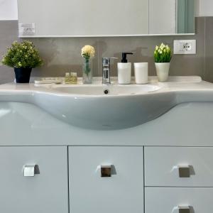 ein weißes Waschbecken mit Blumen drauf in der Unterkunft Bnbook Quadrilocale Italia in Rho