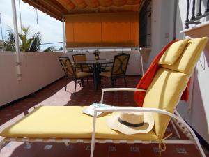 a yellow chair and a table on a balcony at Apartamento Caracola in Chipiona